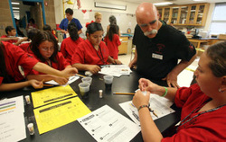 Ian Hanna, top right, a teacher in the DREAMS program, advises students in a forensics lab. (Rudy Gutierrez / El Paso Times)